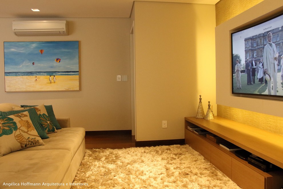 Foto de salón abierto contemporáneo de tamaño medio con paredes beige, suelo de madera oscura, pared multimedia y suelo marrón