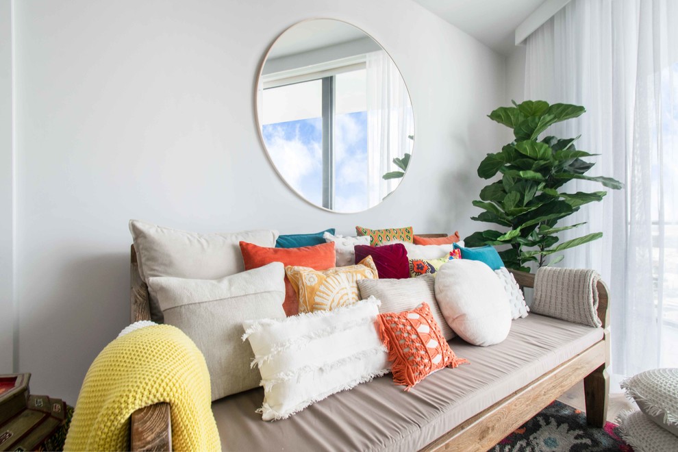 Exemple d'un petit salon mansardé ou avec mezzanine bord de mer avec un mur blanc, parquet clair, un téléviseur encastré et un sol beige.