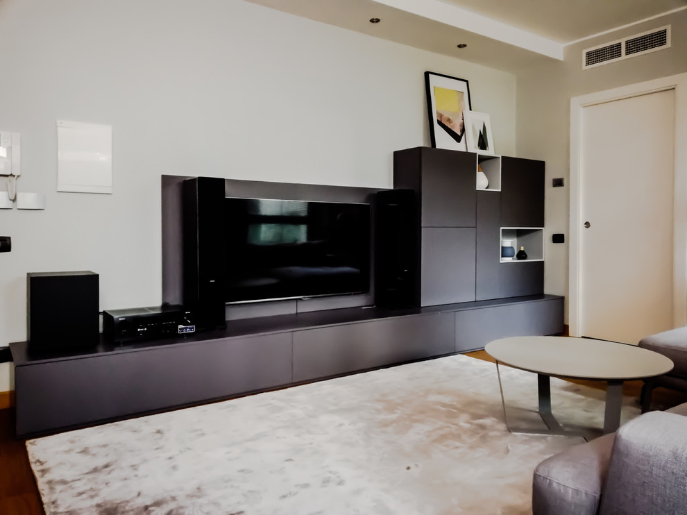 Esempio di un soggiorno minimalista di medie dimensioni e aperto con pavimento in legno massello medio e TV a parete