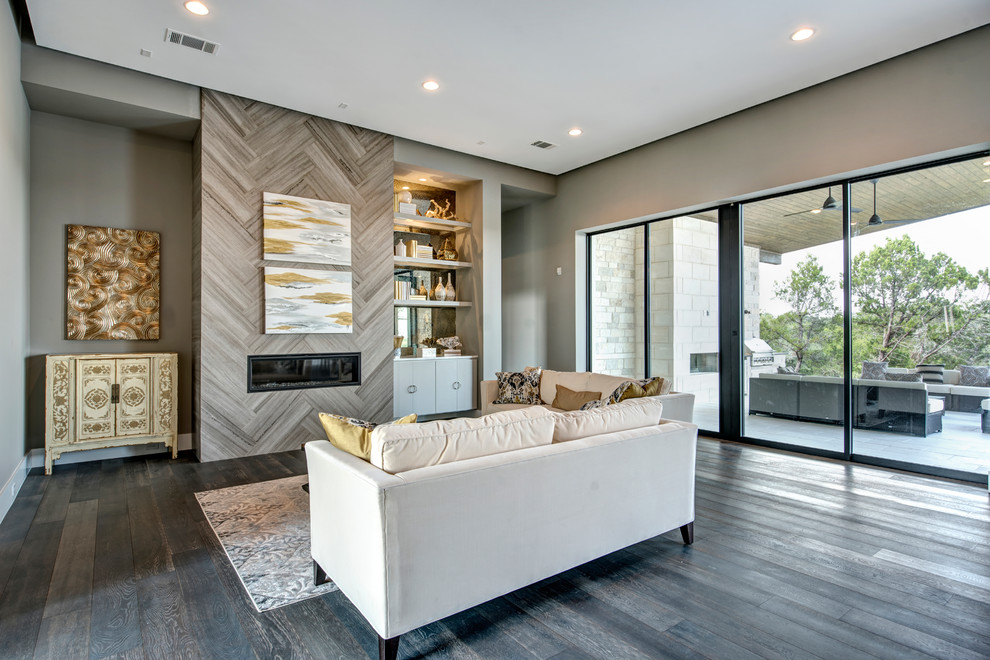 Photo of a medium sized modern open plan living room in Austin with grey walls, dark hardwood flooring, a standard fireplace and a tiled fireplace surround.