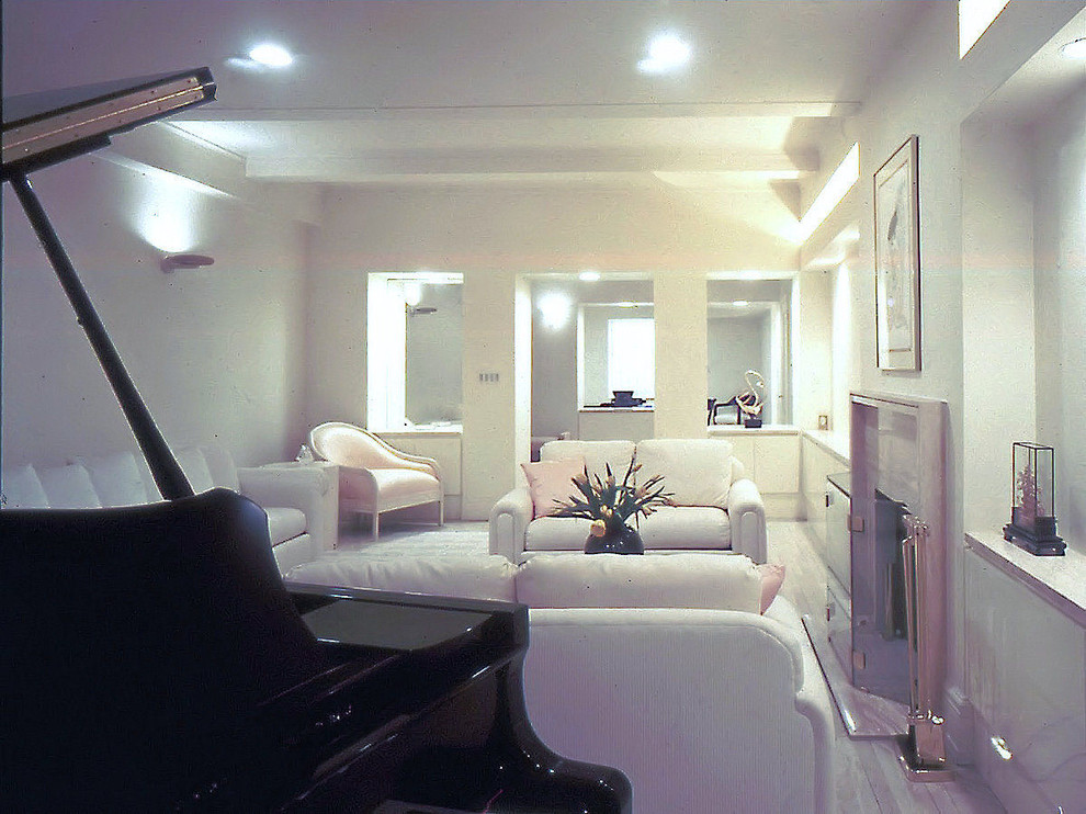 На фото: огромная двухуровневая гостиная комната в современном стиле с белыми стенами, светлым паркетным полом, стандартным камином, фасадом камина из камня и бежевым полом без телевизора с
