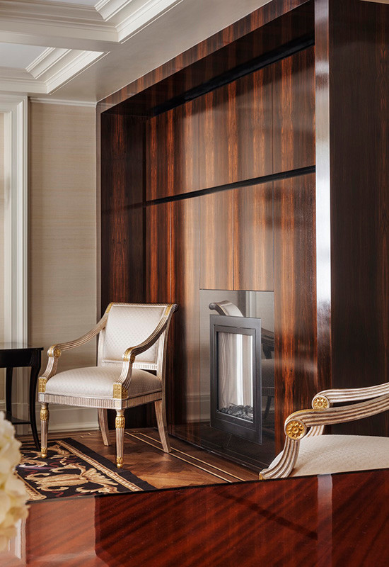 Idées déco pour un salon contemporain avec un mur beige, un sol en bois brun et un manteau de cheminée en bois.