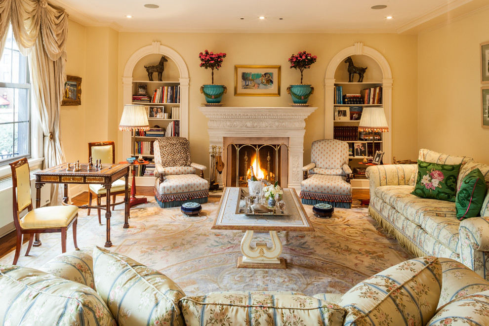 Large classic enclosed living room in New York with beige walls, medium hardwood flooring, a standard fireplace, a plastered fireplace surround, no tv and brown floors.