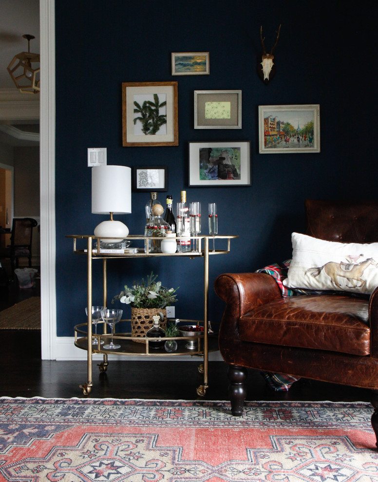 На фото: изолированная гостиная комната среднего размера в стиле неоклассика (современная классика) с синими стенами, темным паркетным полом и домашним баром без камина с