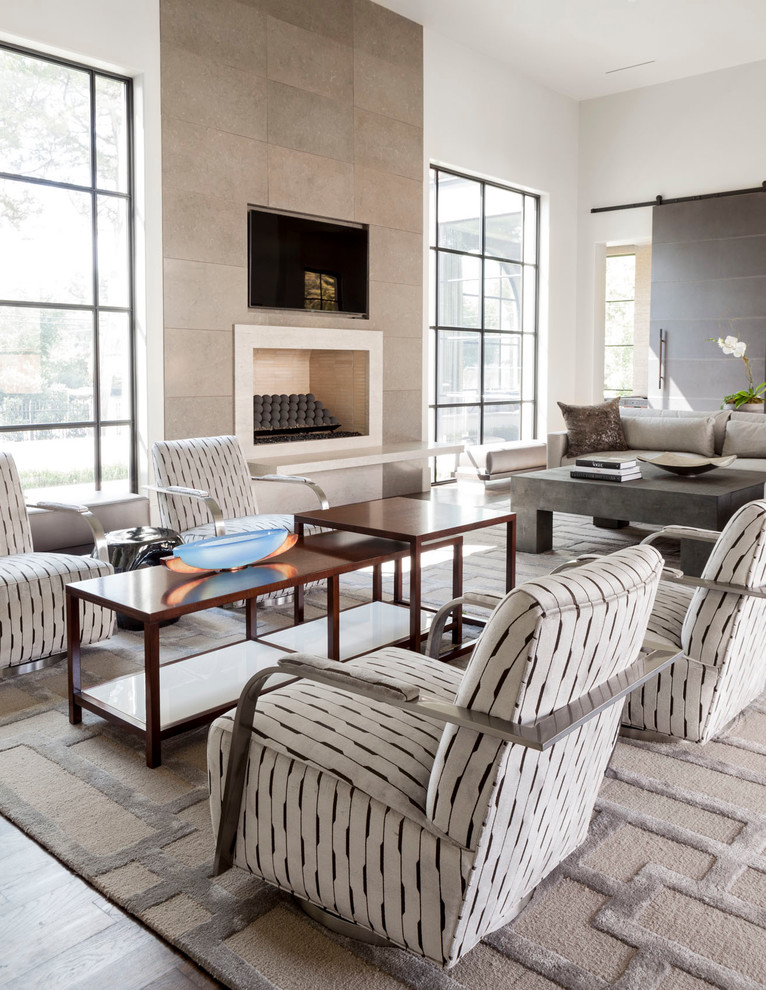 This is an example of a contemporary living room in Dallas with white walls, a standard fireplace and a wall mounted tv.
