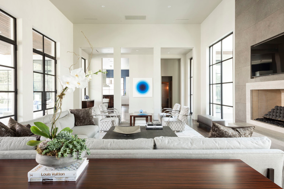 Geräumiges, Offenes Klassisches Wohnzimmer mit weißer Wandfarbe, braunem Holzboden, Kamin, Kaminumrandung aus Stein und TV-Wand in Dallas