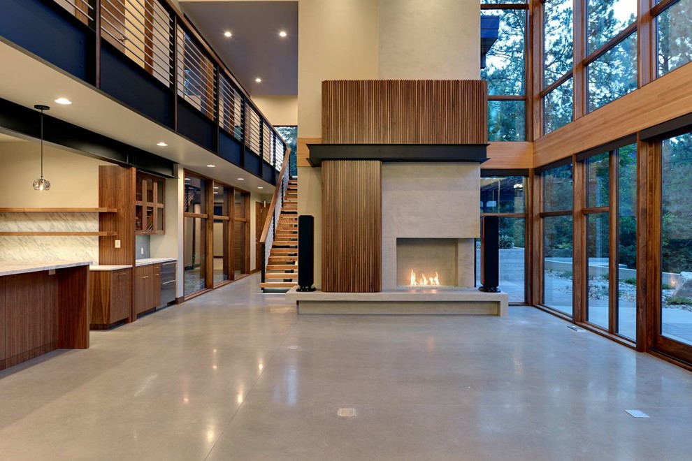 シアトルにある高級な広いモダンスタイルのおしゃれなLDK (ベージュの壁、コンクリートの床、標準型暖炉、コンクリートの暖炉まわり) の写真