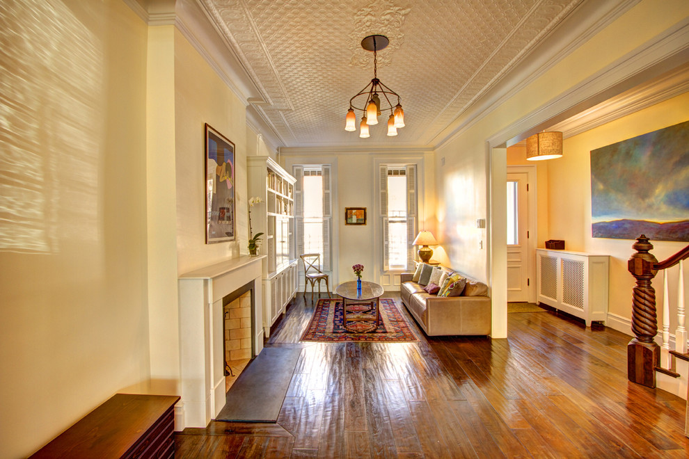 На фото: гостиная комната в классическом стиле с желтыми стенами с
