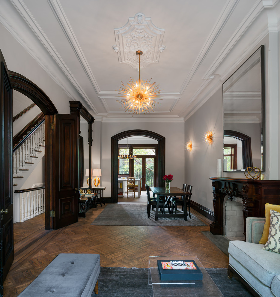 Réalisation d'un salon tradition fermé avec une salle de réception, un mur blanc, parquet foncé et une cheminée standard.