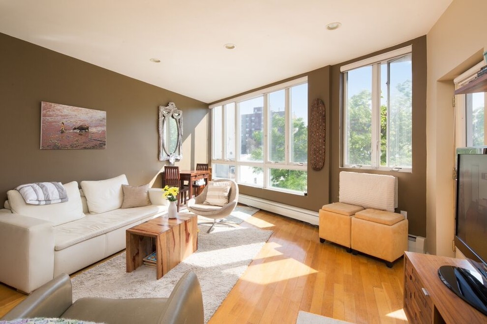 Esempio di un piccolo soggiorno moderno chiuso con sala formale, pareti marroni, TV autoportante e pavimento in legno massello medio