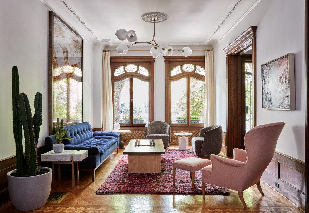 Esempio di un soggiorno classico con sala formale, pareti bianche, pavimento in legno massello medio e pavimento marrone