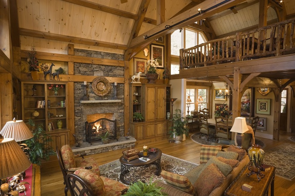 Example of a large arts and crafts loft-style medium tone wood floor living room design in Charlotte with a standard fireplace and a stone fireplace