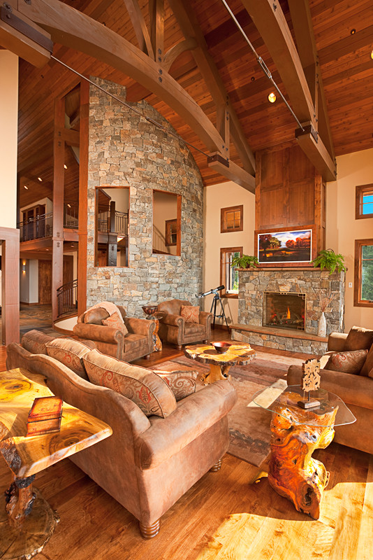 Inspiration for a large rustic formal and open concept medium tone wood floor and brown floor living room remodel in Seattle with beige walls, a standard fireplace, a stone fireplace and no tv