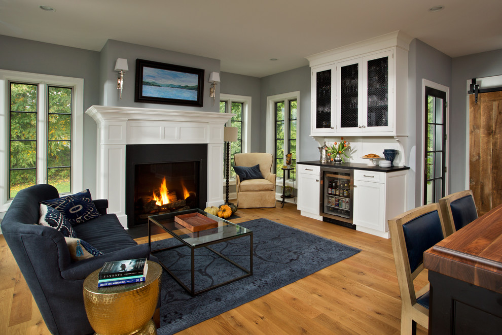 Kleines, Fernseherloses, Offenes Klassisches Wohnzimmer mit Hausbar, grauer Wandfarbe, braunem Holzboden, Kamin und Kaminumrandung aus Holz in Boston