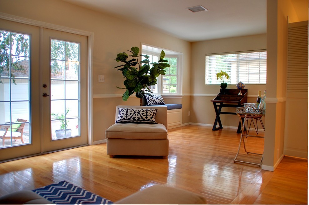 Immagine di un soggiorno tradizionale di medie dimensioni e aperto con sala formale, pareti beige, parquet chiaro e nessuna TV