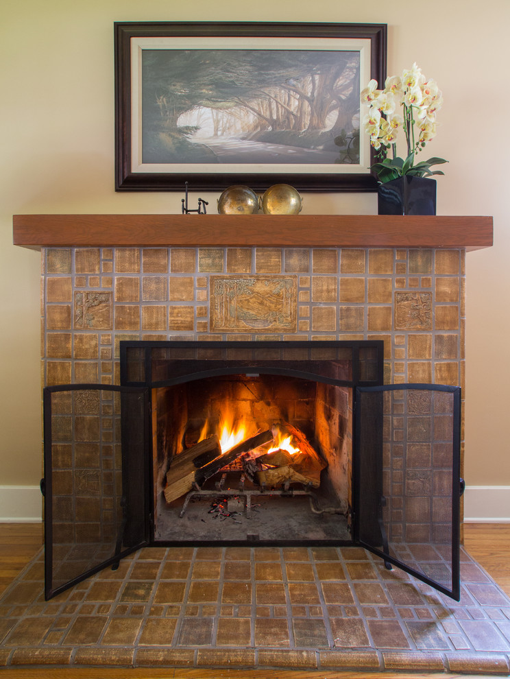 Example of a mid-sized classic enclosed medium tone wood floor living room design in Los Angeles with beige walls, a standard fireplace and a tile fireplace
