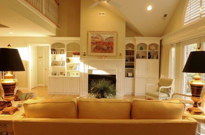 Exemple d'un grand salon chic ouvert avec une salle de réception, un mur beige, parquet clair, une cheminée standard, un manteau de cheminée en bois et un téléviseur encastré.