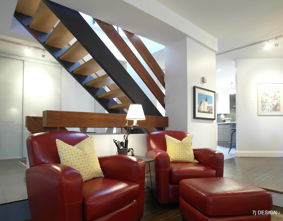 Imagen de salón contemporáneo grande con paredes grises, suelo de madera en tonos medios, marco de chimenea de ladrillo y televisor colgado en la pared
