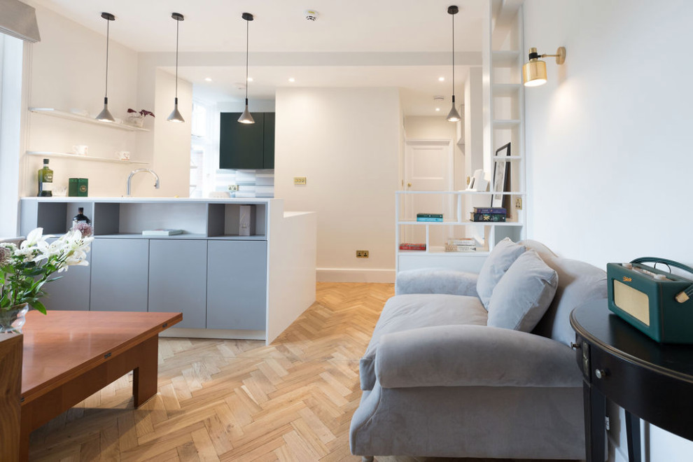 Idee per un piccolo soggiorno design aperto con pareti beige, parquet chiaro, nessun camino e pavimento marrone