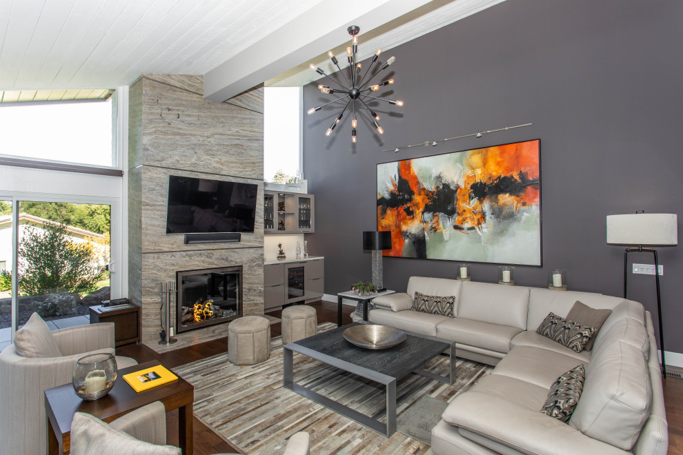 ダラスにある高級な広いコンテンポラリースタイルのおしゃれなLDK (ベージュの壁、濃色無垢フローリング、標準型暖炉、石材の暖炉まわり、壁掛け型テレビ、茶色い床) の写真