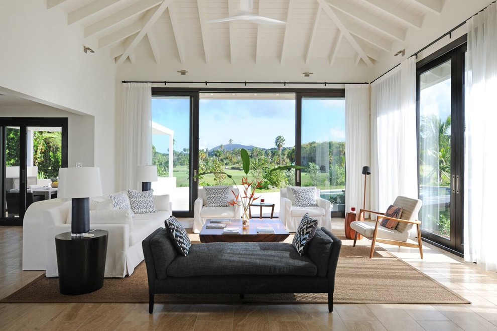 Foto di un grande soggiorno tropicale aperto con pareti bianche, pavimento in legno massello medio e tappeto