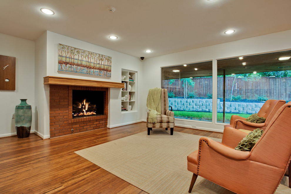ダラスにある広いミッドセンチュリースタイルのおしゃれなリビング (白い壁、竹フローリング、標準型暖炉、レンガの暖炉まわり、テレビなし) の写真