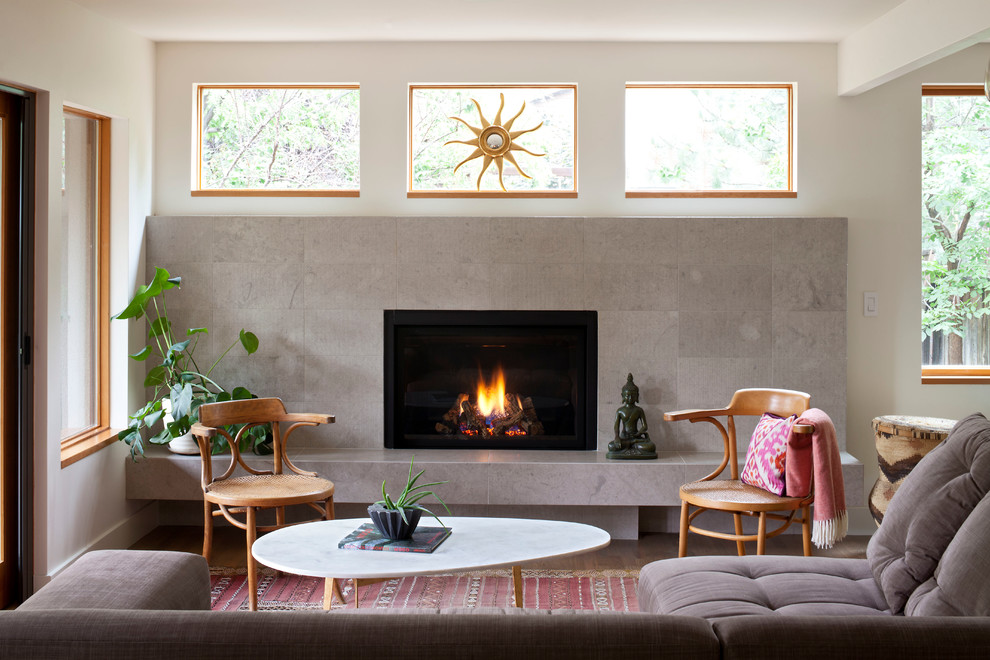 Example of a mid-sized trendy formal light wood floor and brown floor living room design in Denver with a standard fireplace, no tv, a tile fireplace and white walls