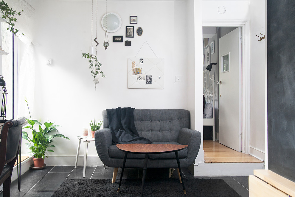 Стильный дизайн: маленькая открытая гостиная комната в стиле фьюжн с белыми стенами, полом из керамической плитки и черным полом без телевизора, камина для на участке и в саду - последний тренд