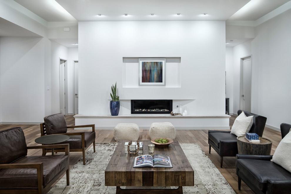 Repräsentatives, Fernseherloses, Großes, Offenes Modernes Wohnzimmer mit weißer Wandfarbe, Gaskamin, braunem Holzboden, verputzter Kaminumrandung und braunem Boden in Austin