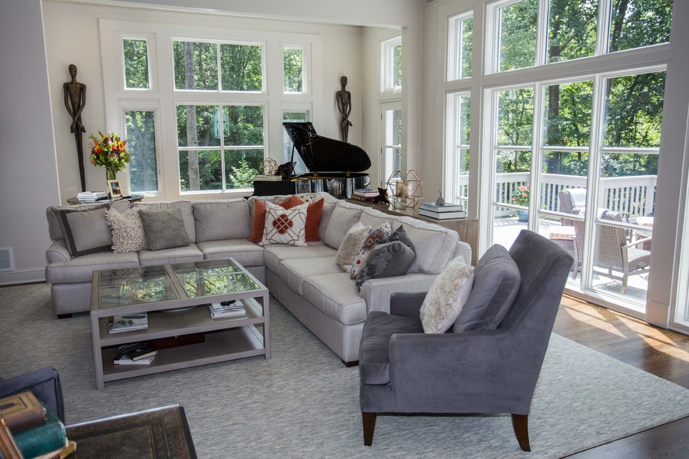 Inspiration for a large traditional enclosed living room in New York with grey walls, medium hardwood flooring, a standard fireplace, a stone fireplace surround, a wall mounted tv and grey floors.