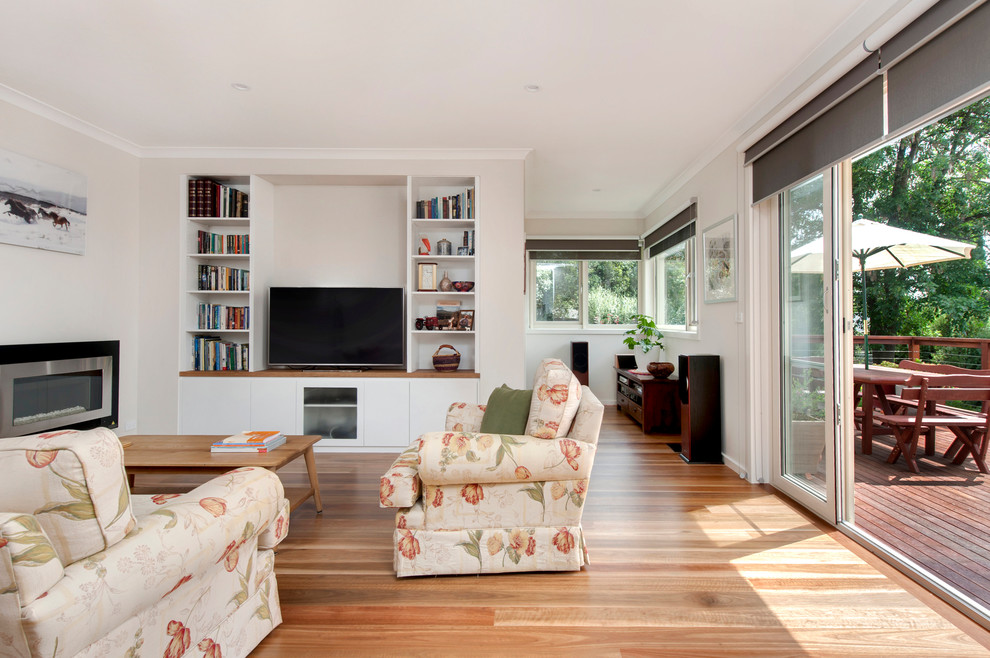 Mittelgroßes, Offenes Modernes Wohnzimmer mit weißer Wandfarbe, braunem Holzboden, Kamin, Kaminumrandung aus Metall und Multimediawand in Canberra - Queanbeyan