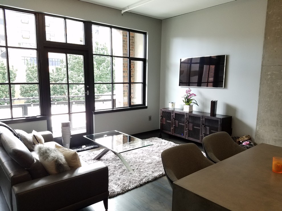 Idee per un piccolo soggiorno contemporaneo stile loft con pareti grigie, parquet scuro, TV a parete e sala formale