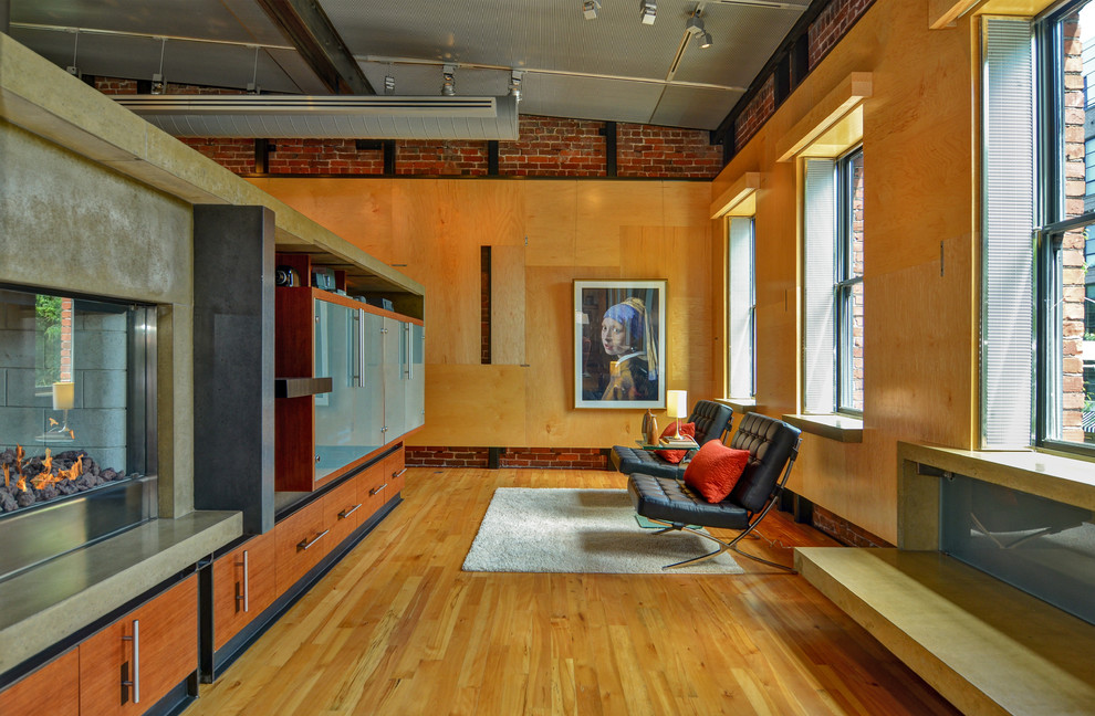 Foto på ett industriellt vardagsrum, med mellanmörkt trägolv och en bred öppen spis