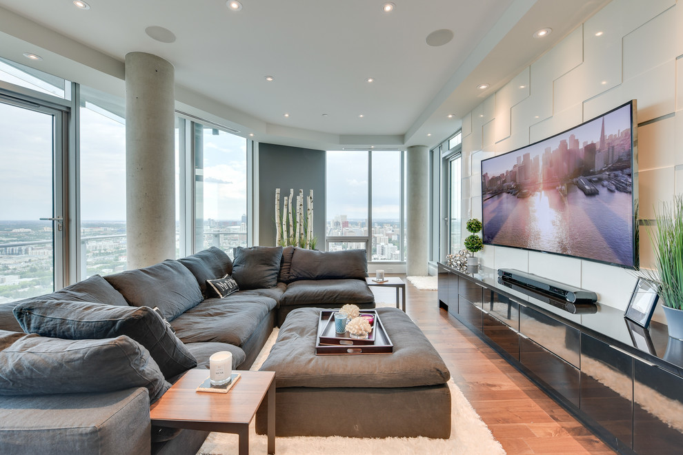 Design ideas for an expansive contemporary open plan living room in Calgary with a music area, white walls, medium hardwood flooring, no fireplace, a stone fireplace surround, a wall mounted tv and brown floors.