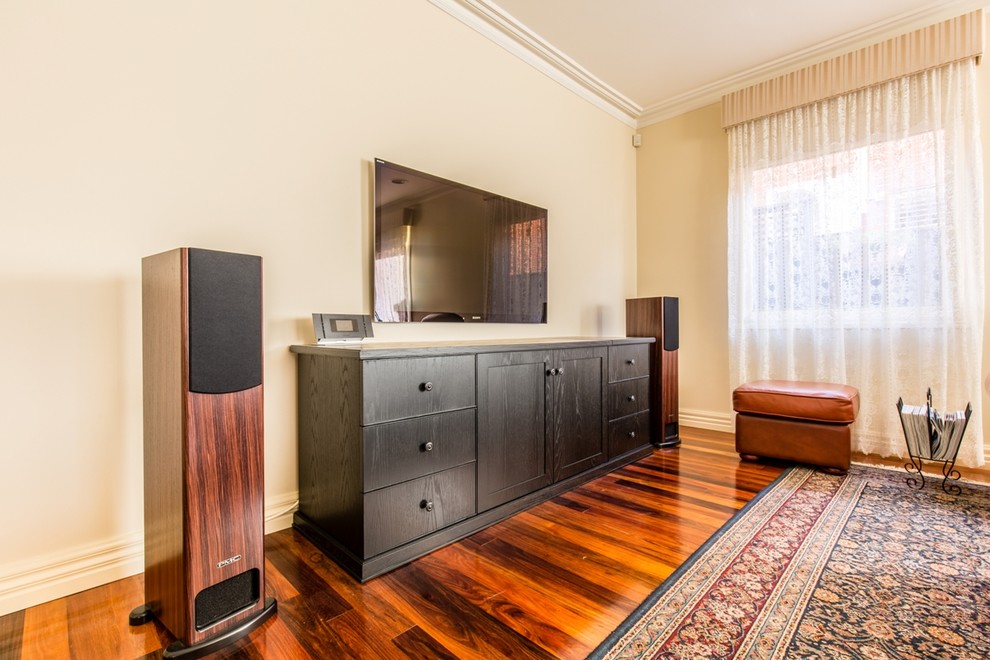 Mittelgroßes Klassisches Wohnzimmer mit weißer Wandfarbe, braunem Holzboden und TV-Wand in Melbourne