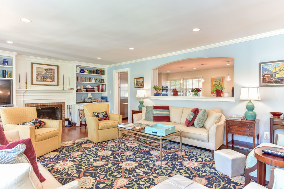 Mittelgroßes, Repräsentatives, Abgetrenntes Modernes Wohnzimmer mit blauer Wandfarbe, braunem Holzboden, Kamin, Kaminumrandung aus Backstein und braunem Boden