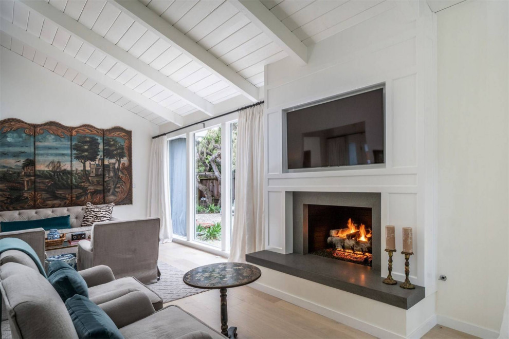 Example of a mid-sized beach style formal and open concept light wood floor and beige floor living room design in San Luis Obispo with white walls, a standard fireplace, a wood fireplace surround and a media wall