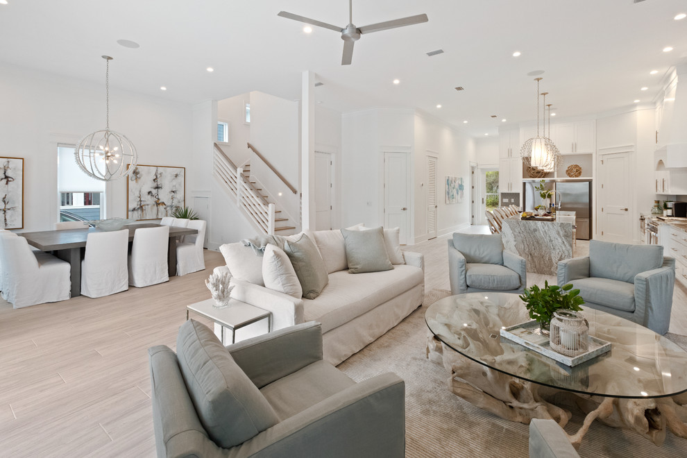 Photo of a coastal open plan living room in Other with white walls, light hardwood flooring and beige floors.