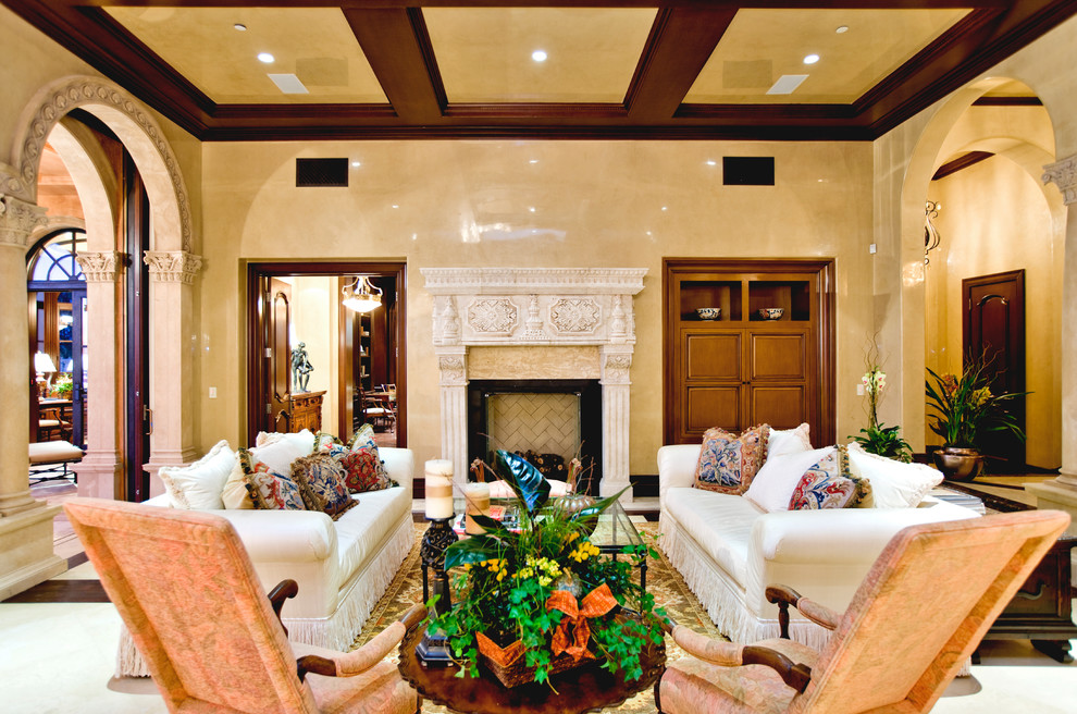 Стильный дизайн: парадная гостиная комната в классическом стиле с желтыми стенами, стандартным камином и фасадом камина из камня - последний тренд
