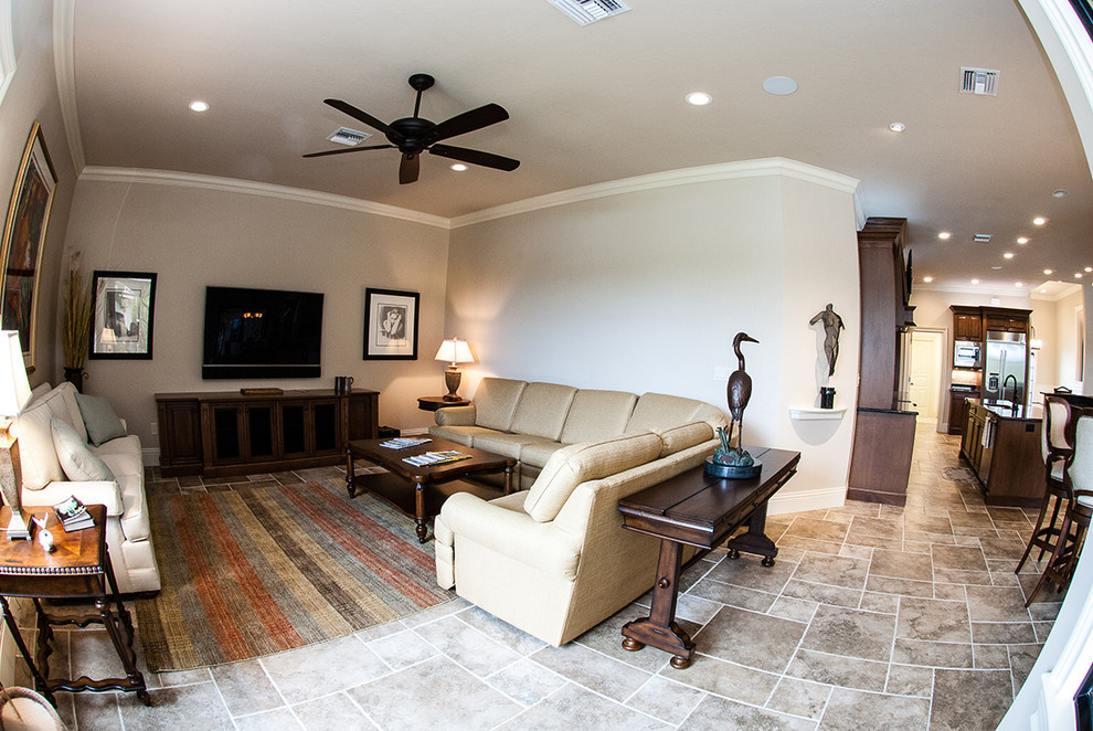 Foto de salón abierto tradicional de tamaño medio con paredes beige, televisor colgado en la pared y suelo beige
