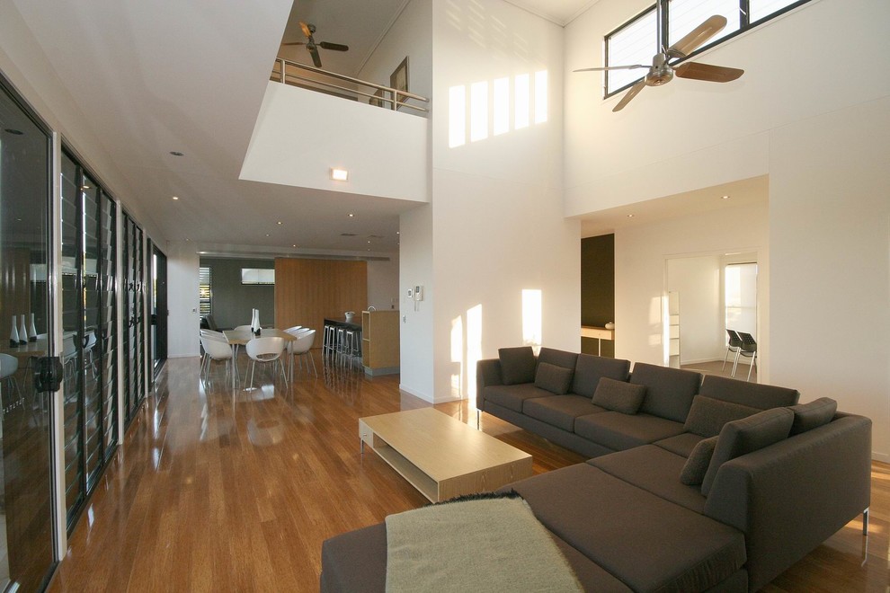 Cette photo montre un salon tendance de taille moyenne et ouvert avec un mur gris et parquet en bambou.