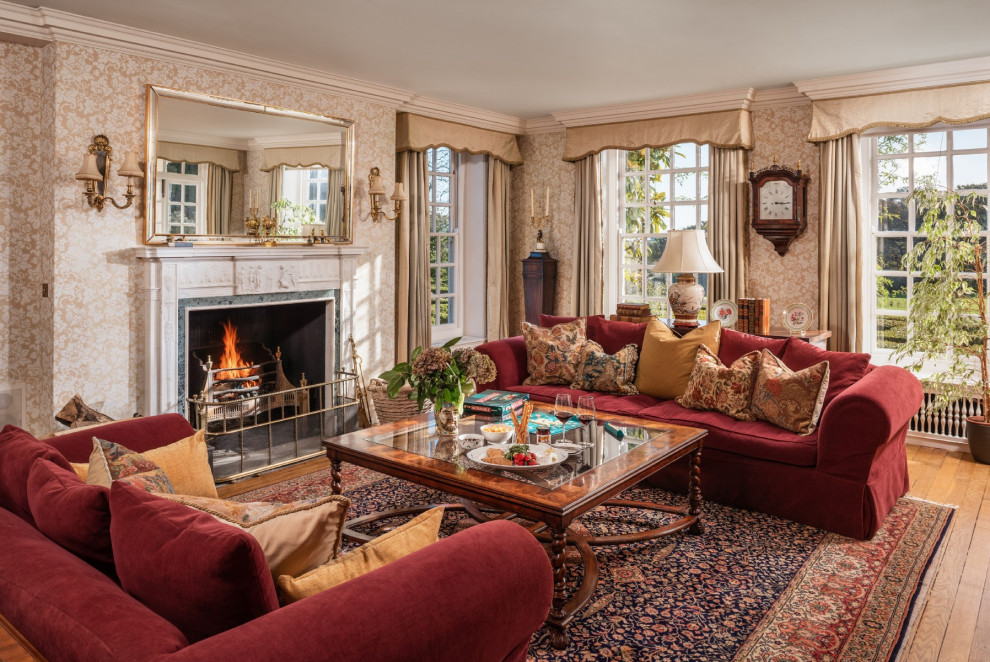 Large traditional living room in Sussex with beige walls, medium hardwood flooring, a standard fireplace and brown floors.