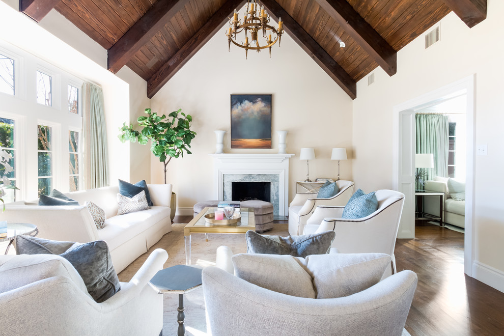 Klassisches Wohnzimmer mit beiger Wandfarbe, Kamin, Kaminumrandung aus Stein, braunem Boden und braunem Holzboden in Austin
