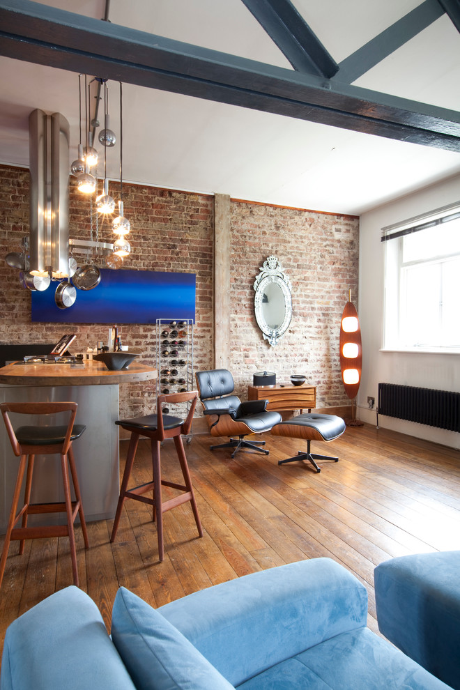 This is an example of an expansive industrial mezzanine living room in London with a home bar, white walls, medium hardwood flooring, no fireplace and no tv.