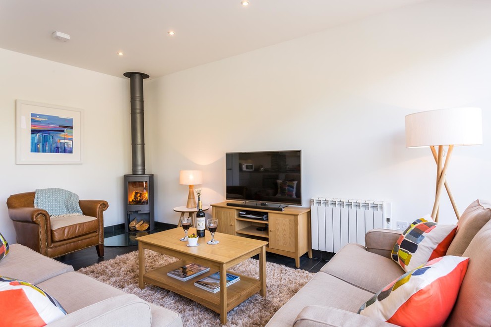 Immagine di un soggiorno contemporaneo con pareti bianche, stufa a legna e TV autoportante