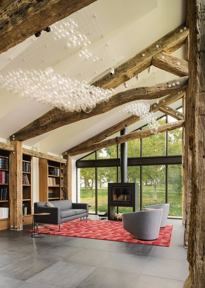 Idée de décoration pour un salon design ouvert avec un mur beige, un poêle à bois et un sol gris.