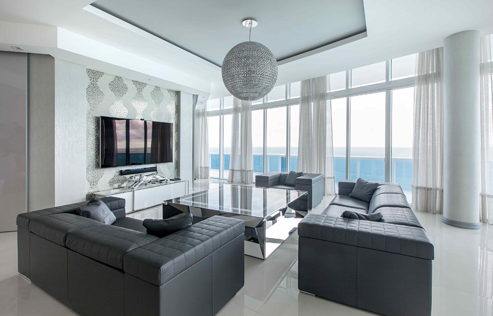 Large trendy open concept porcelain tile and white floor living room photo in Miami with gray walls and a wall-mounted tv