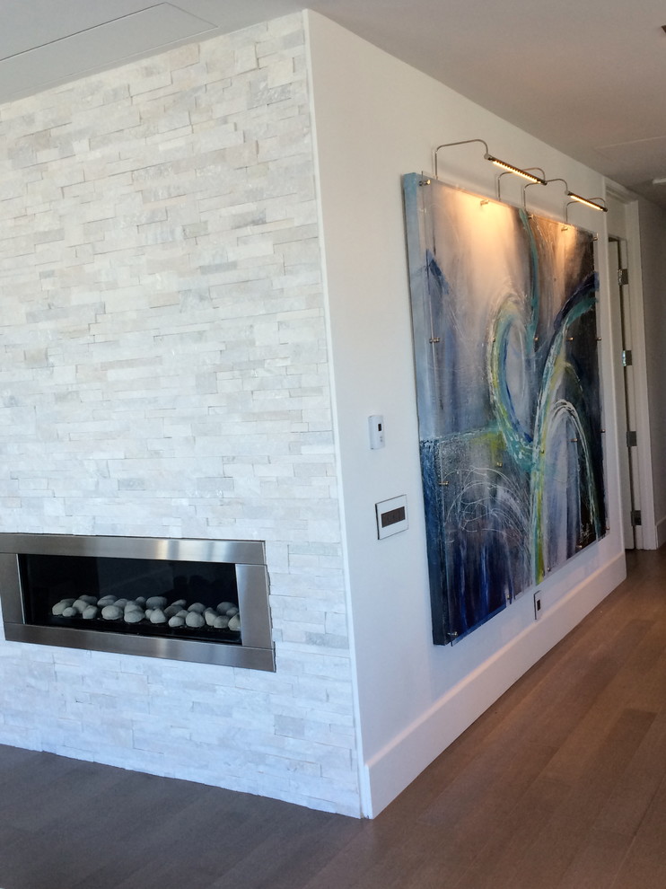 Свежая идея для дизайна: открытая гостиная комната среднего размера в стиле модернизм с белыми стенами, полом из бамбука, стандартным камином, фасадом камина из камня и скрытым телевизором - отличное фото интерьера