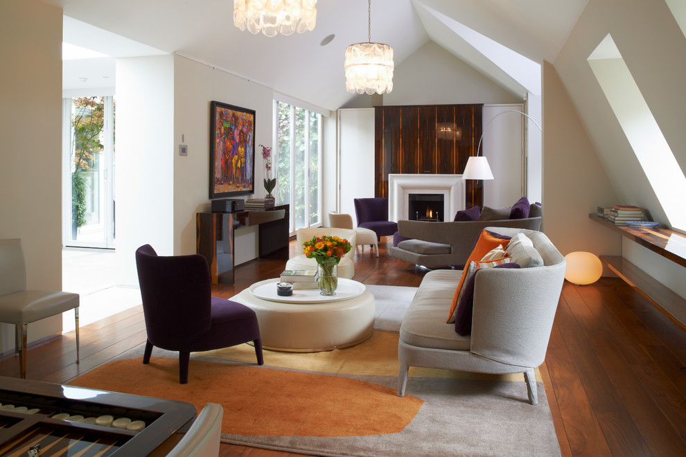 Immagine di un soggiorno design chiuso con pareti bianche, pavimento in legno massello medio e camino classico