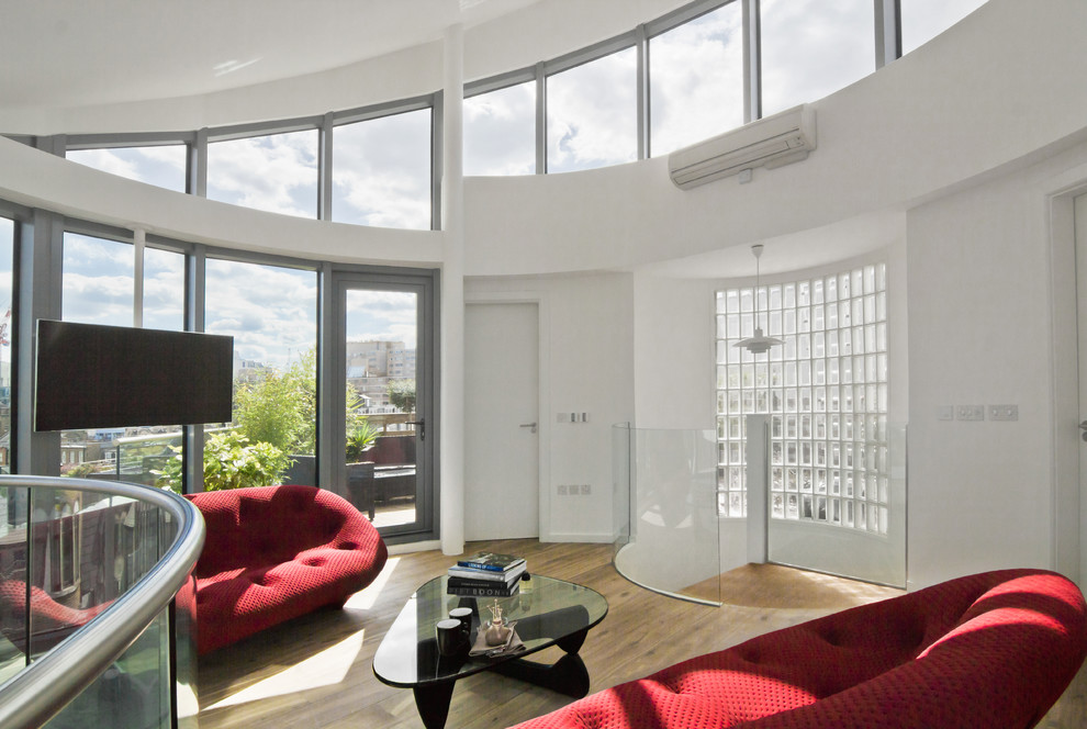 Mittelgroßes Modernes Wohnzimmer im Loft-Stil mit weißer Wandfarbe, braunem Holzboden und TV-Wand in London